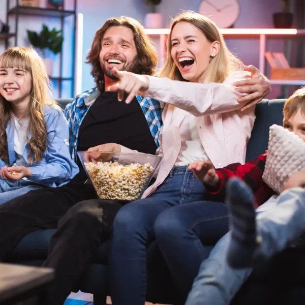 Happy family watching movies at home with popcorn using IPTV Smarters 8k Pro subscription on Smart TV – best IPTV Smarters Player 2025. IPTV Subscription, IPTV Smarters Player